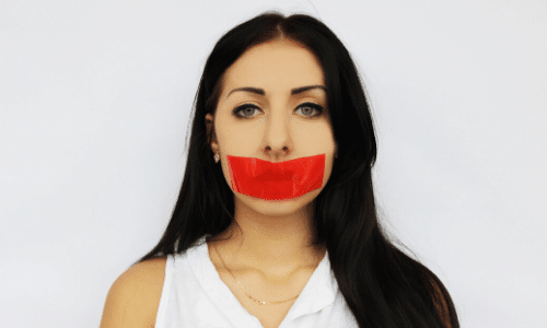 headshot of a woman with red tape over her mouth to symbolize words that should be banned from your business vocabulary