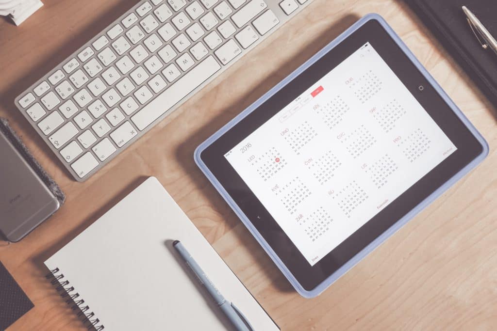 office desk with a social media content calendar on a tablet