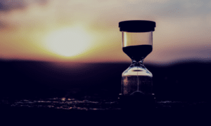 sunset in the background with an hour glass in the foreground