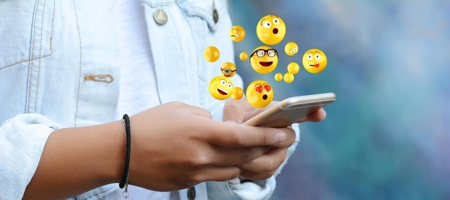 emojis jumping out of a phone screen